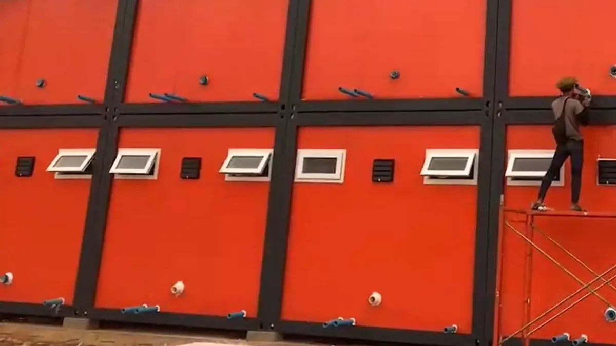Factory-built staff accommodation units arranged around shaded walkways at a tropical hospitality site